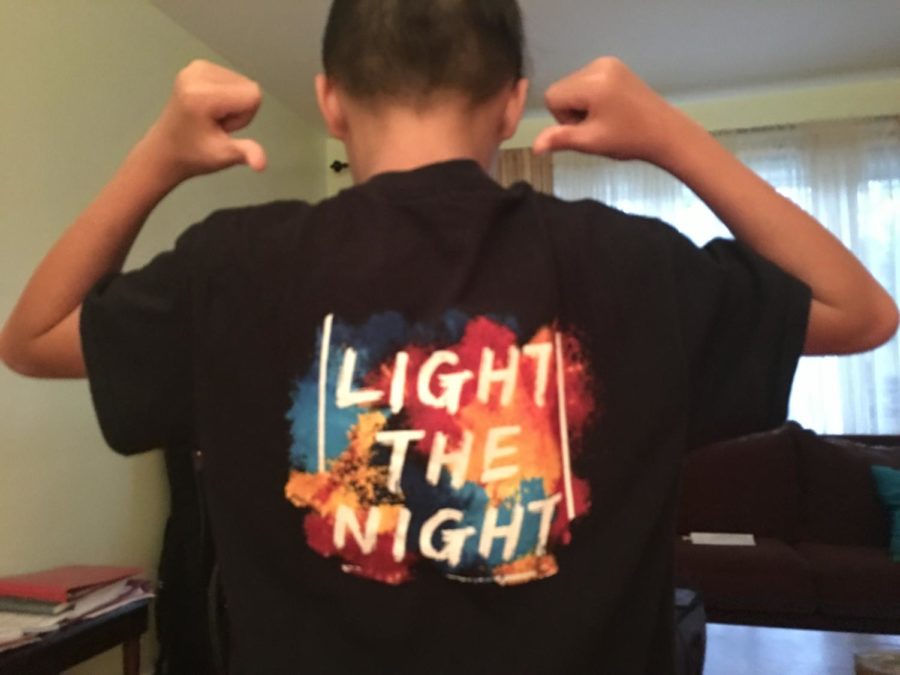 Alex+Cafe%2C+a+seventh+grader+in+the+marching+band%2C+shows+off+his+%22Light+the+Night%22+t-shirt.