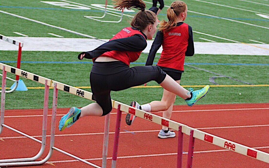 Sophomore+Emma+Callagy+jumps+over+the+hurdle+while+competing+in+an+event+at+a+track+meet.