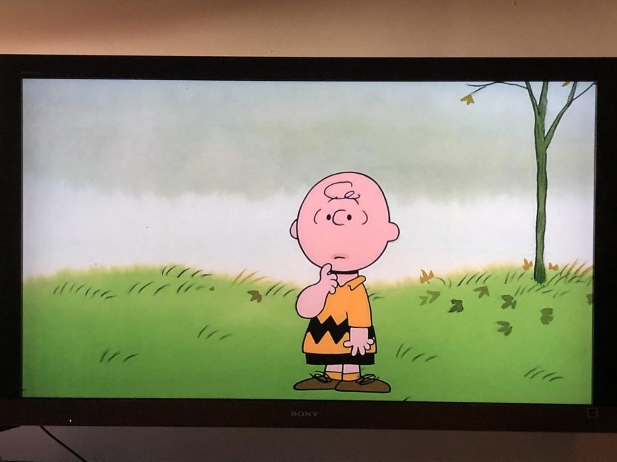 A scene from the opening of A Charlie Brown Thanksgiving playing on a TV.