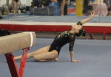 El-Ansari posing after finishing a gold level floor routine in one of her competitions.