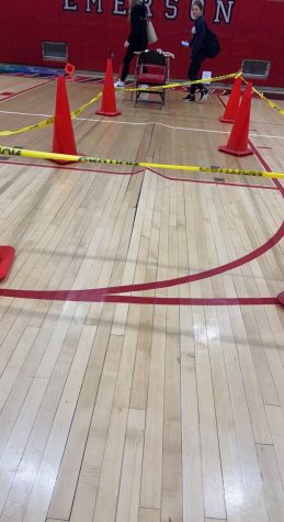 Caution tape and cones surround the warped gymnasium floor.