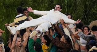 Bad Bunny is lifted up during his uplifting performance.